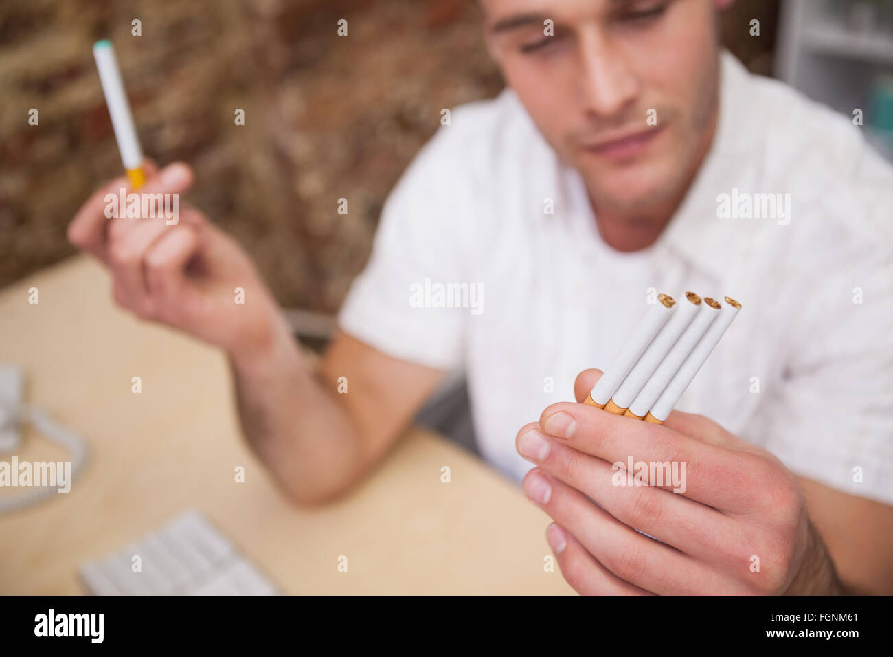 normal cigarettes Man deciding between electronic or normal cigarettes Stock Photo