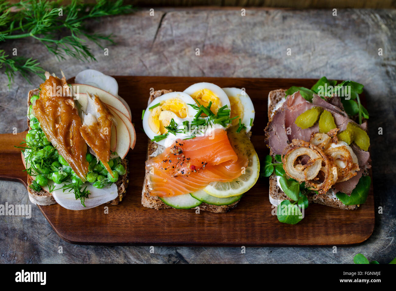 Scandinavian open sandwiches with smoked mackerel, salmon and egg and roast beef and crispy onion Stock Photo