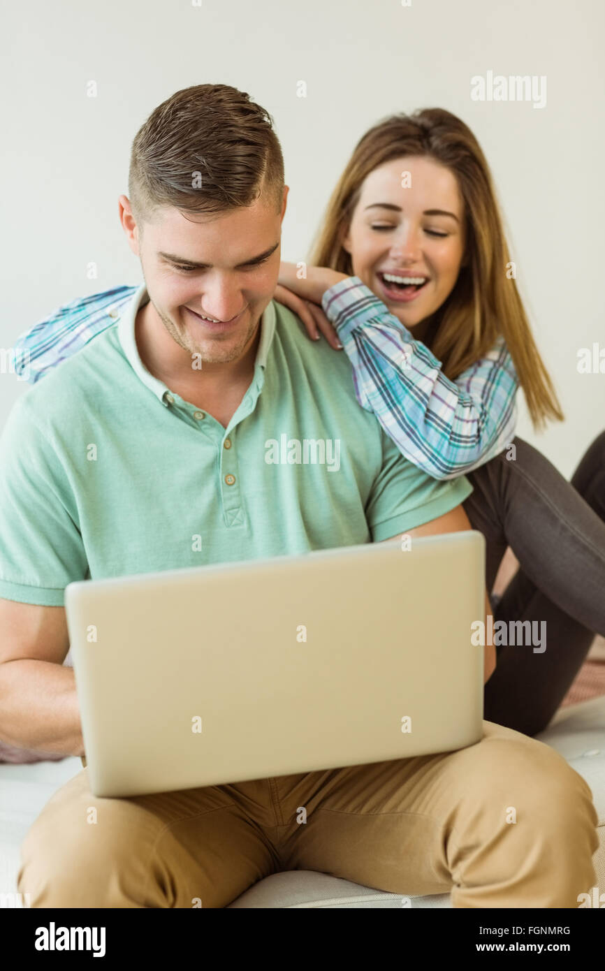 Cute couple relaxing on couch with laptop Stock Photo - Alamy
