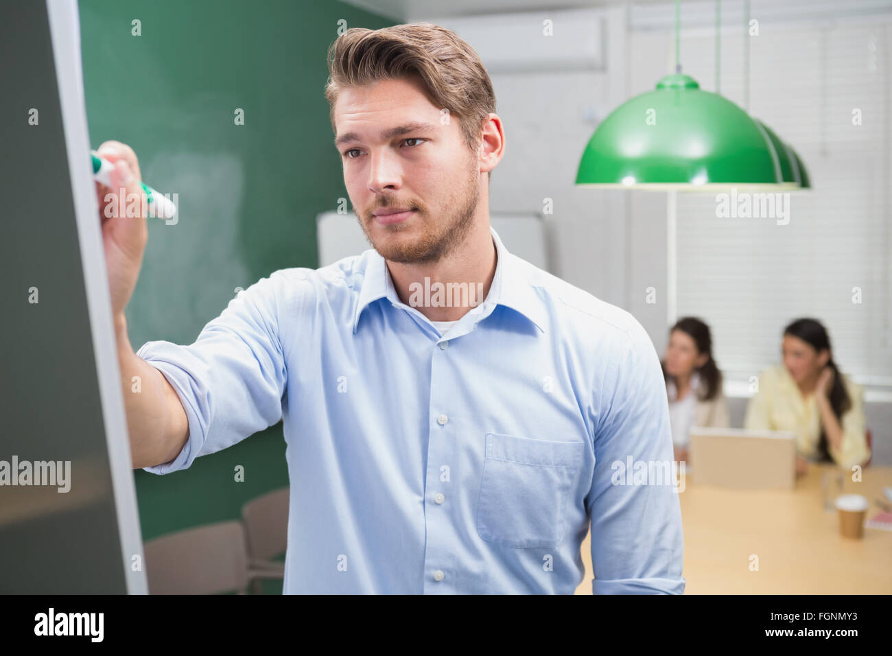 Focused businessman writing on whiteboard with marker Stock Photo Alamy