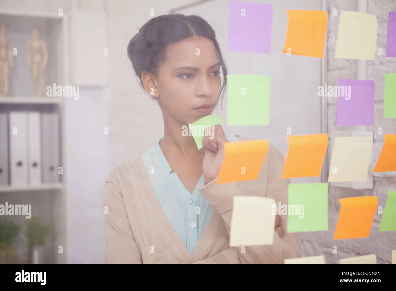 Thoughtful businesswoman looking at sticky notes on window Stock Photo ...