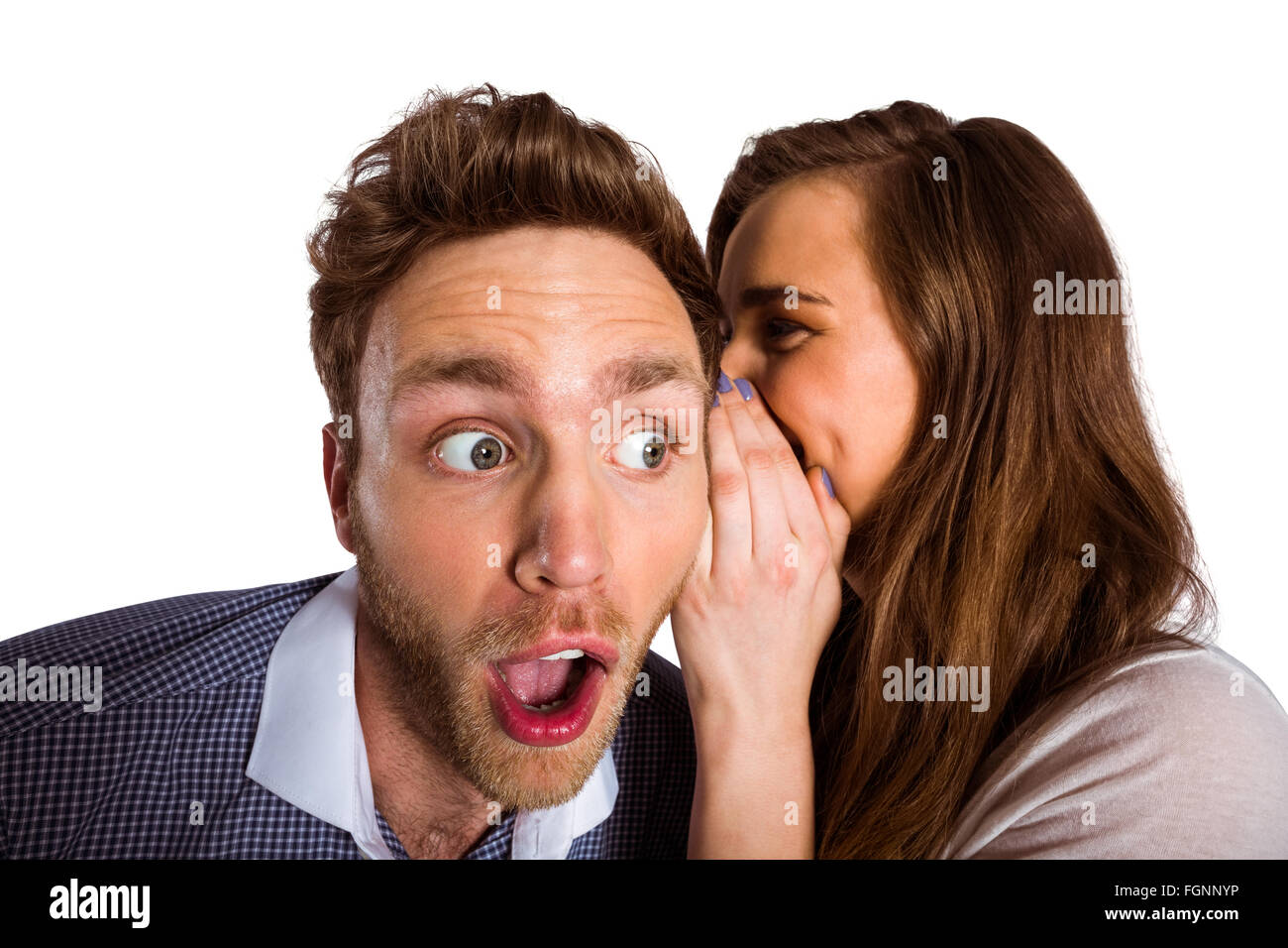 Woman whispering secret into friends ear Stock Photo