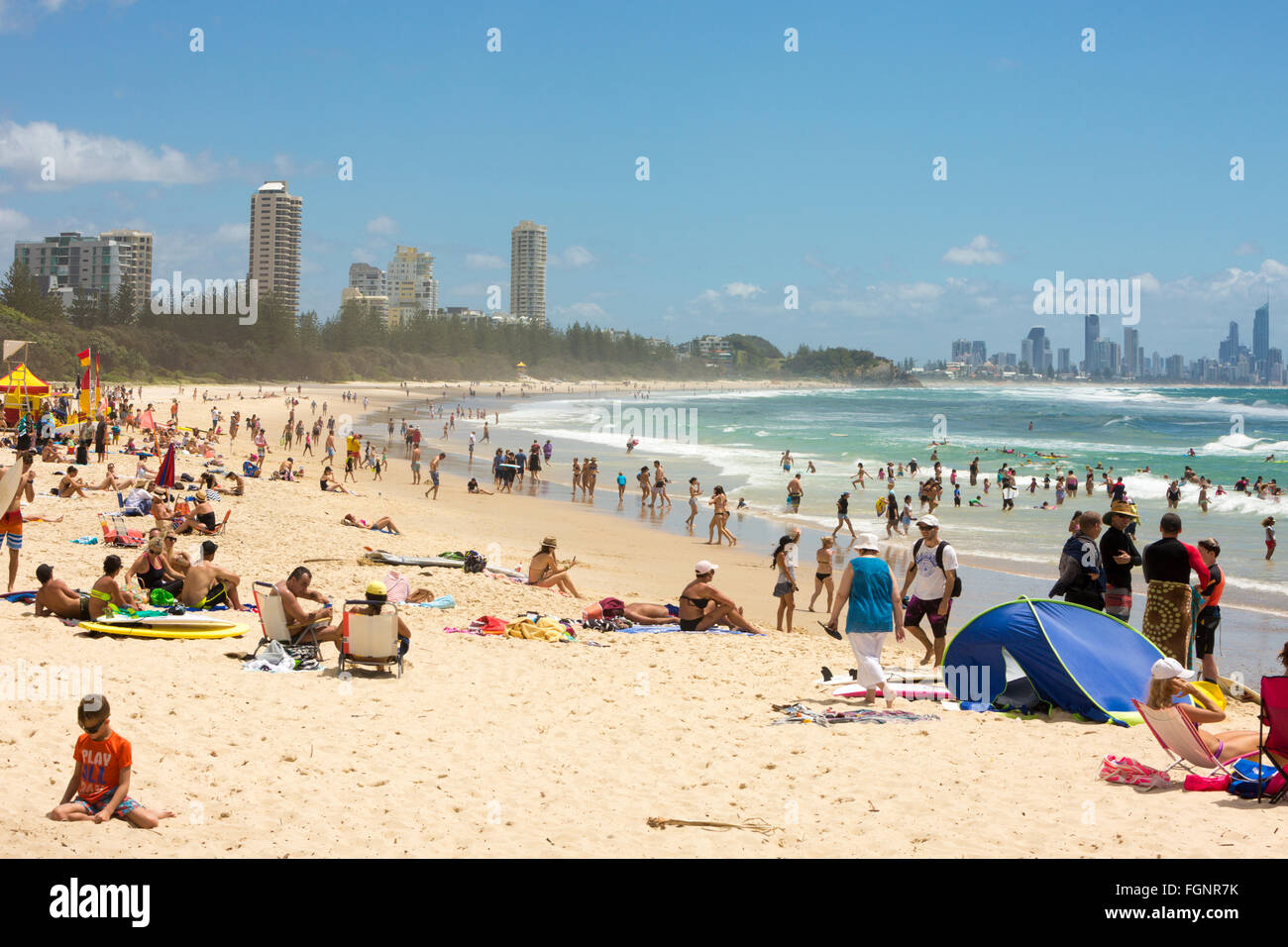 people in the surf ocean at Burleigh Heads with Surfers Paradise in the distance,Gold coast