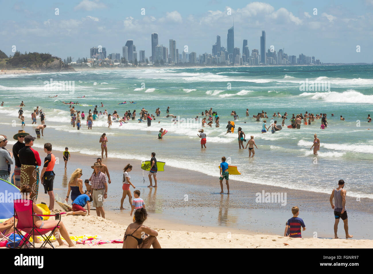 people in the surf ocean at Burleigh Heads with Surfers Paradise in the distance,Gold coast people in the surf ocean at Burleigh Heads with Surfers Paradise in the distance,Gold coast