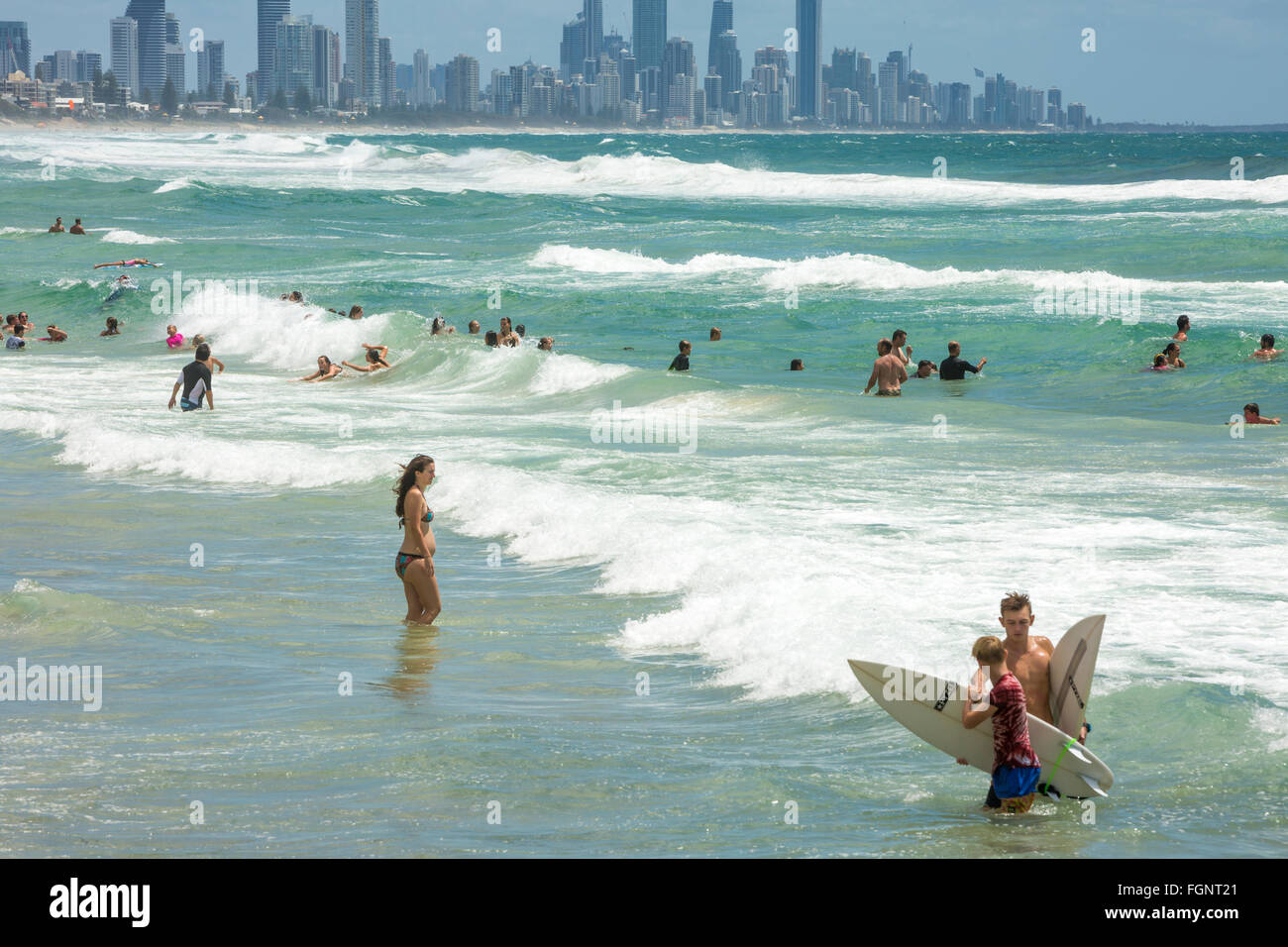 people in the surf ocean at Burleigh Heads with Surfers Paradise in the distance,Gold coast people in the surf ocean at Burleigh Heads with Surfers Paradise in the distance,Gold coast
