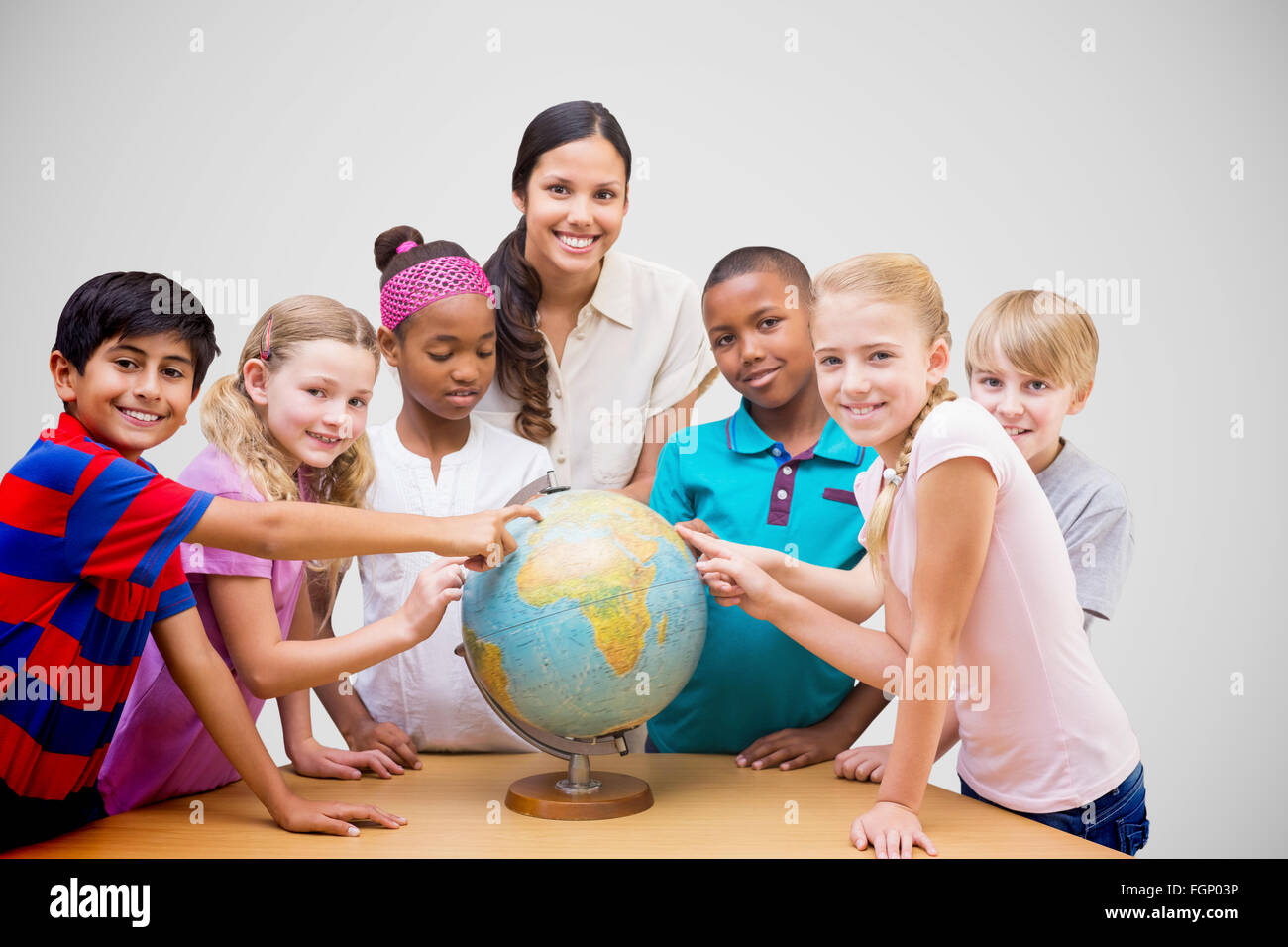 Composite image of cute pupils and teacher looking at globe in library ...