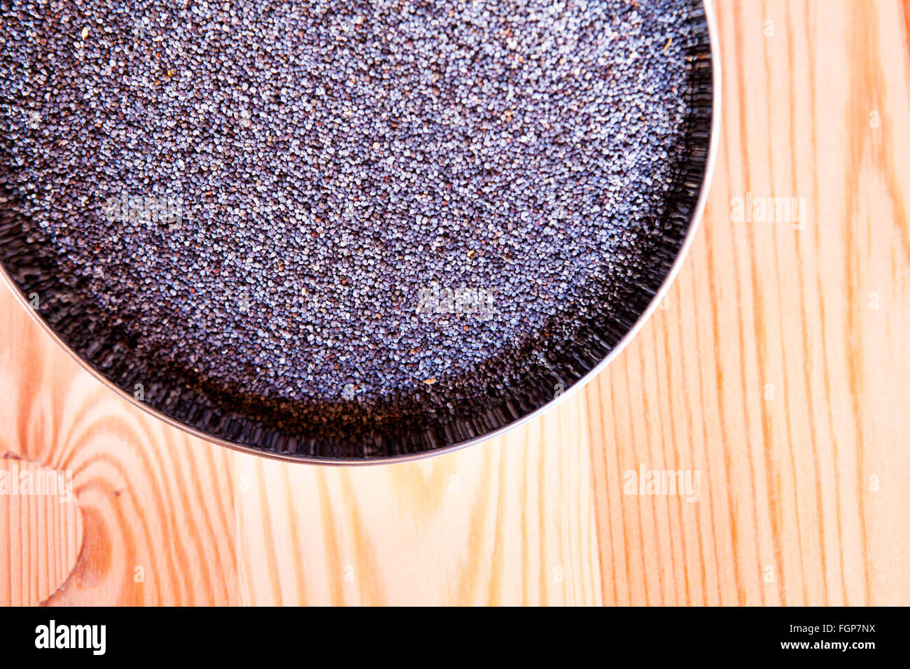 Poppy seeds in bowl Stock Photo