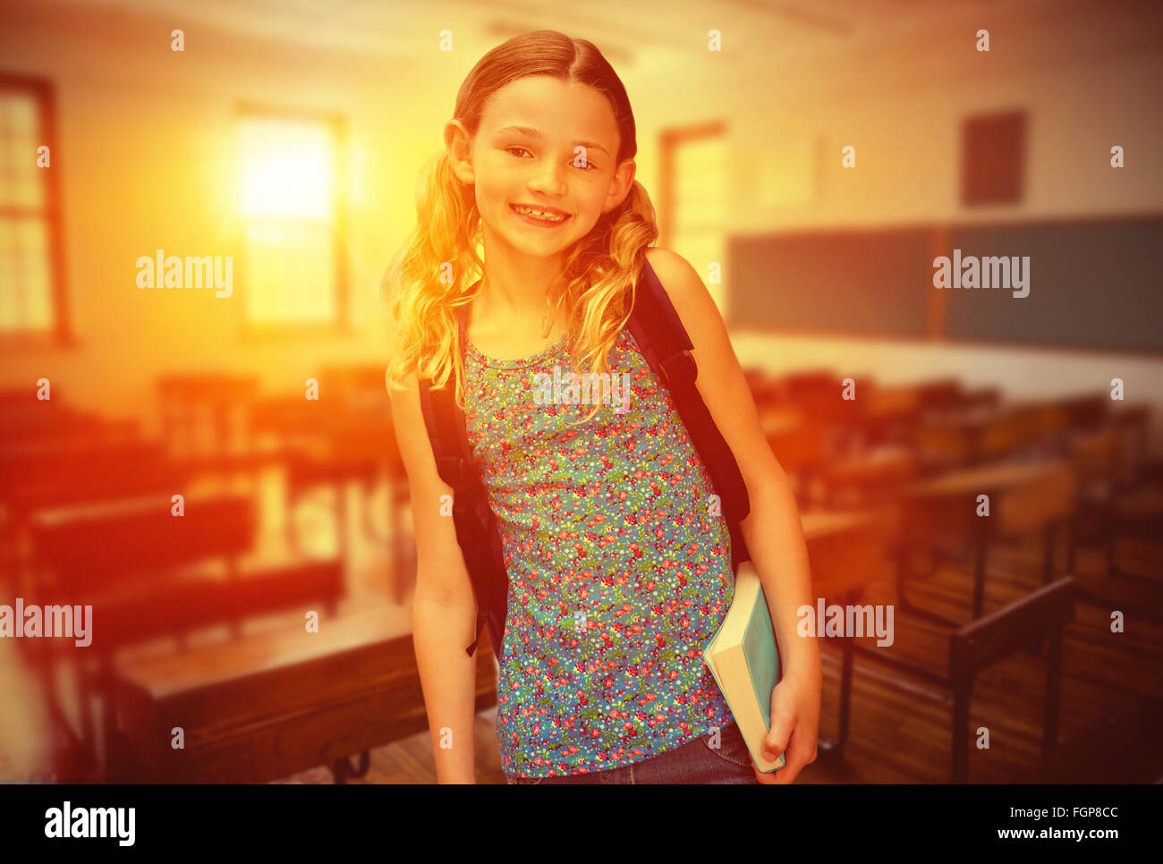 Composite image of cute little girl holding book in library Stock Photo ...