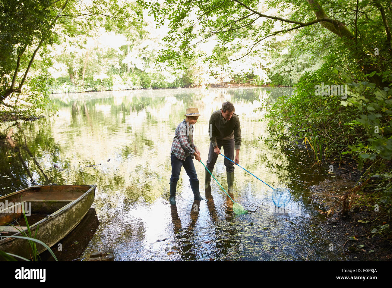 Father and son fishing with nets in forest pond Stock Photo