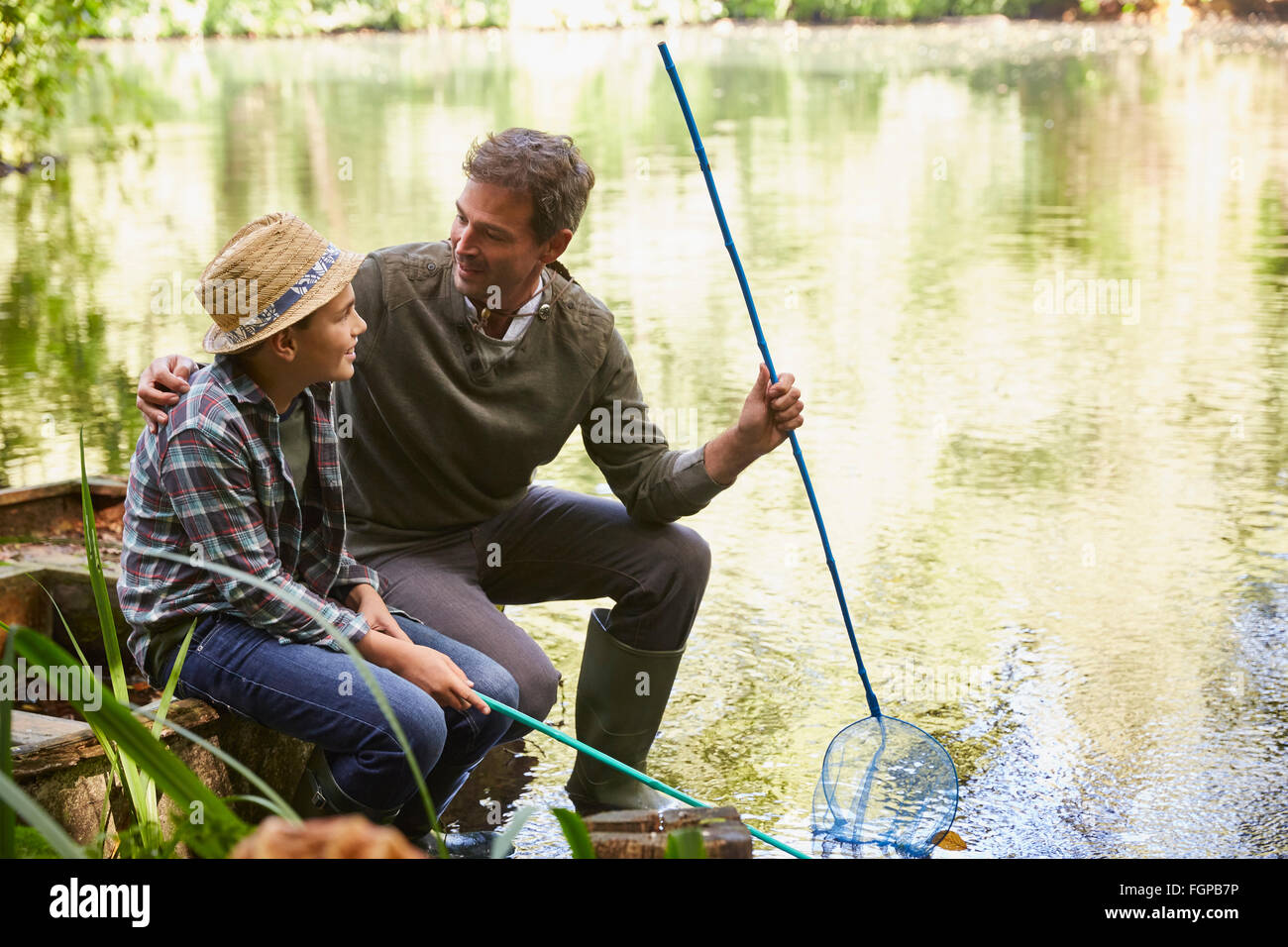 Father and son fishing with nets in pond Stock Photo