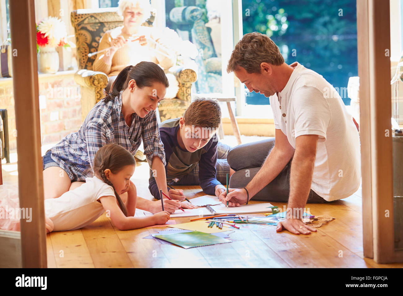 Family drawing and coloring on floor in living room Stock Photo