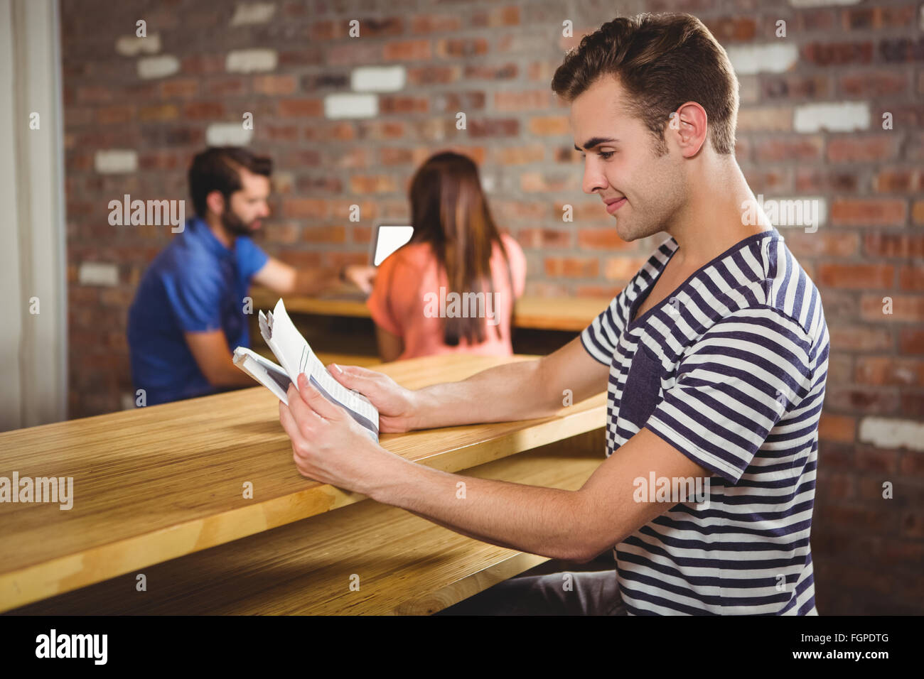 Young man reading a newspaper Stock Photo - Alamy
