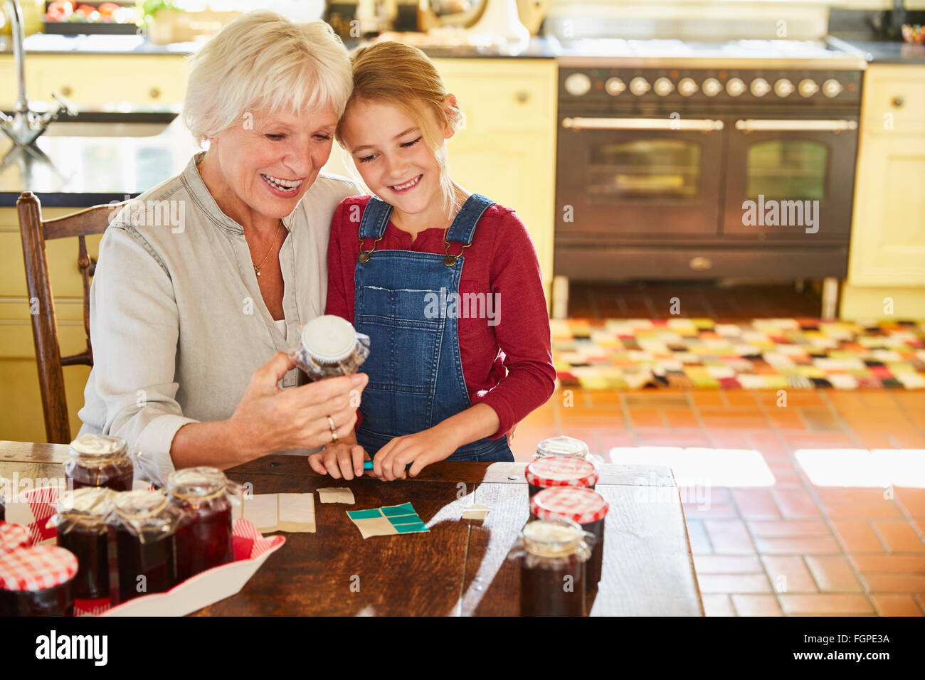 Grandmother and granddaughter canning jam in kitchen Stock Photo