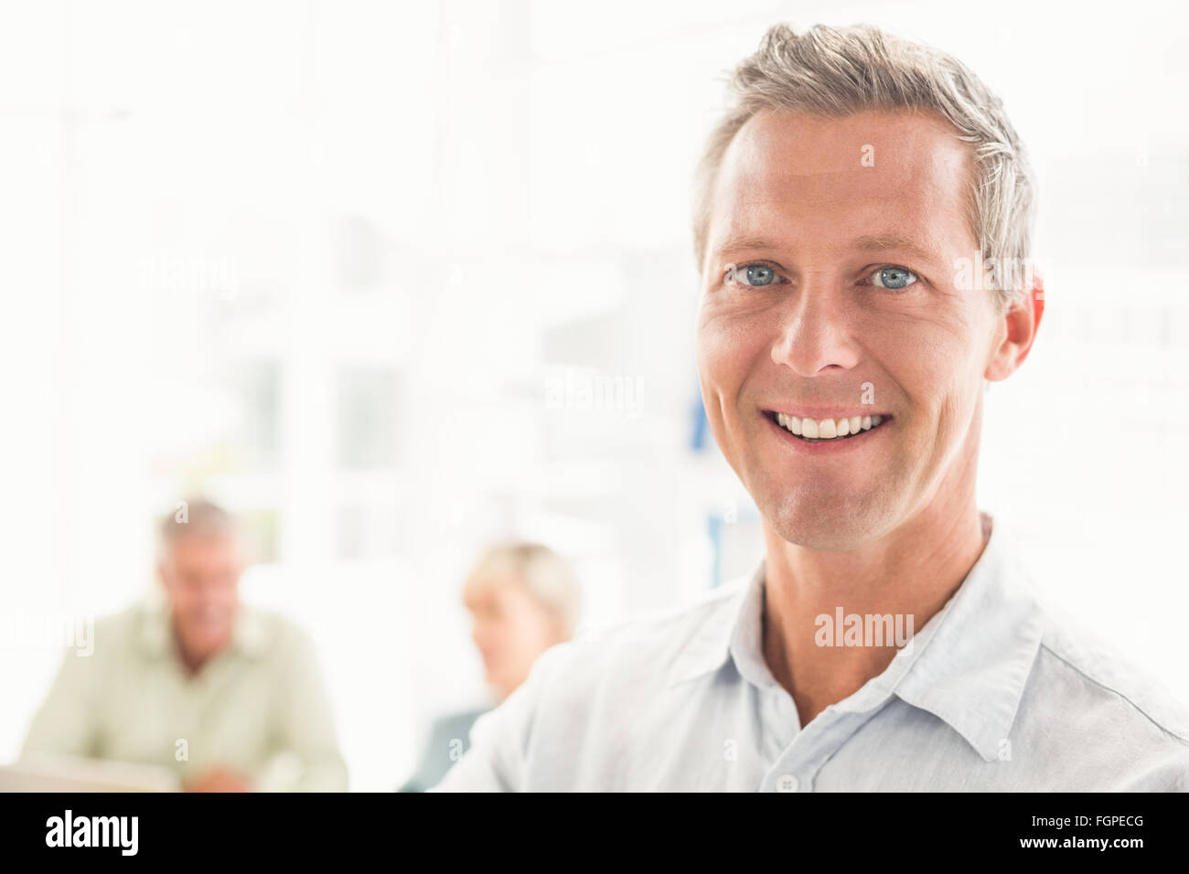 Smiling businessman looking at camera Stock Photo - Alamy