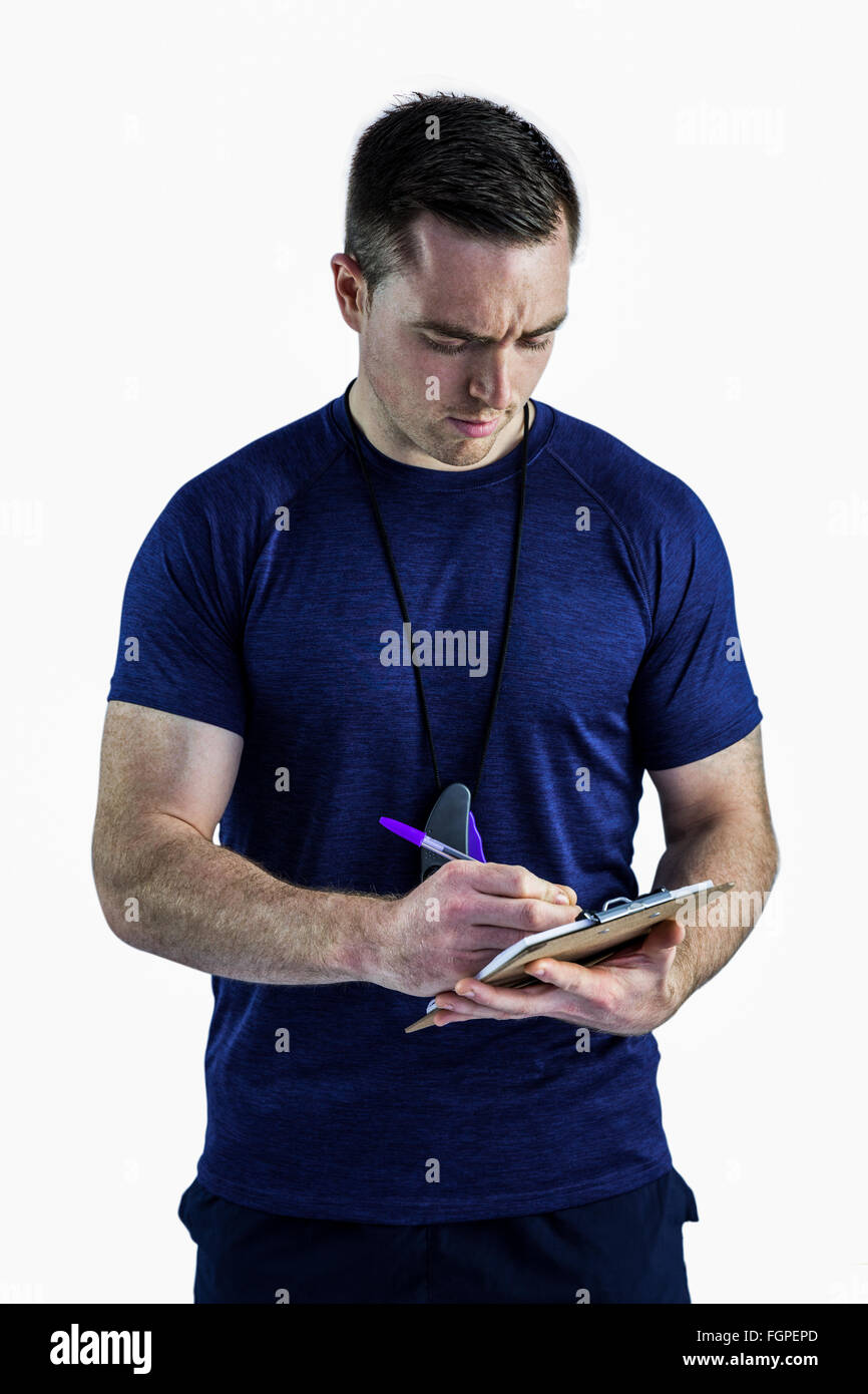 Attentive trainer writing on his clipboard Stock Photo - Alamy