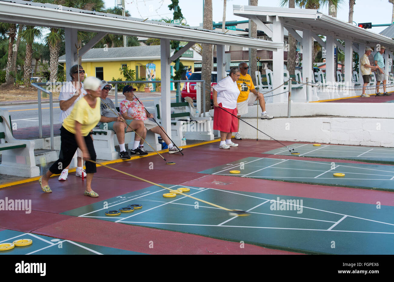 New Smyrna Beach Florida senior retired couples playing shuffleboard in game competition in town on Flaglaer Street Stock Photo