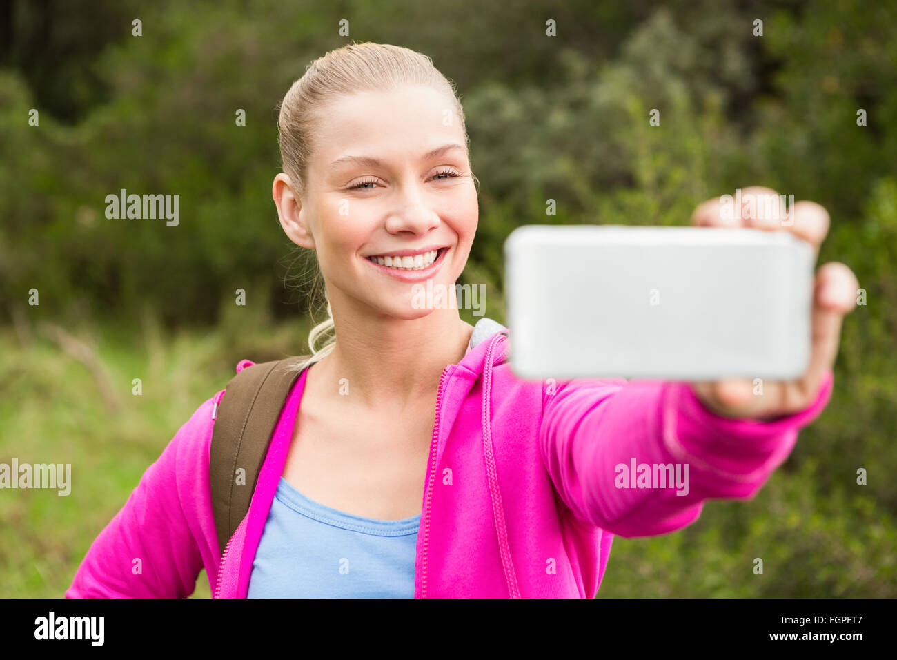 Smiling female hiker taking a selfie Stock Photo - Alamy