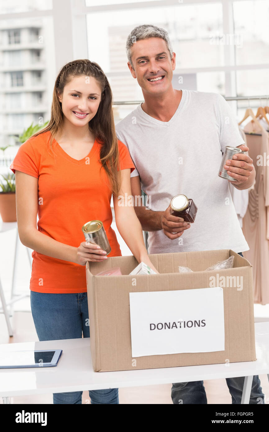 Smiling casual business colleagues sorting donations Stock Photo