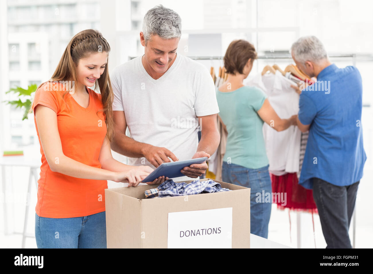 Smiling casual business people sorting donations Stock Photo