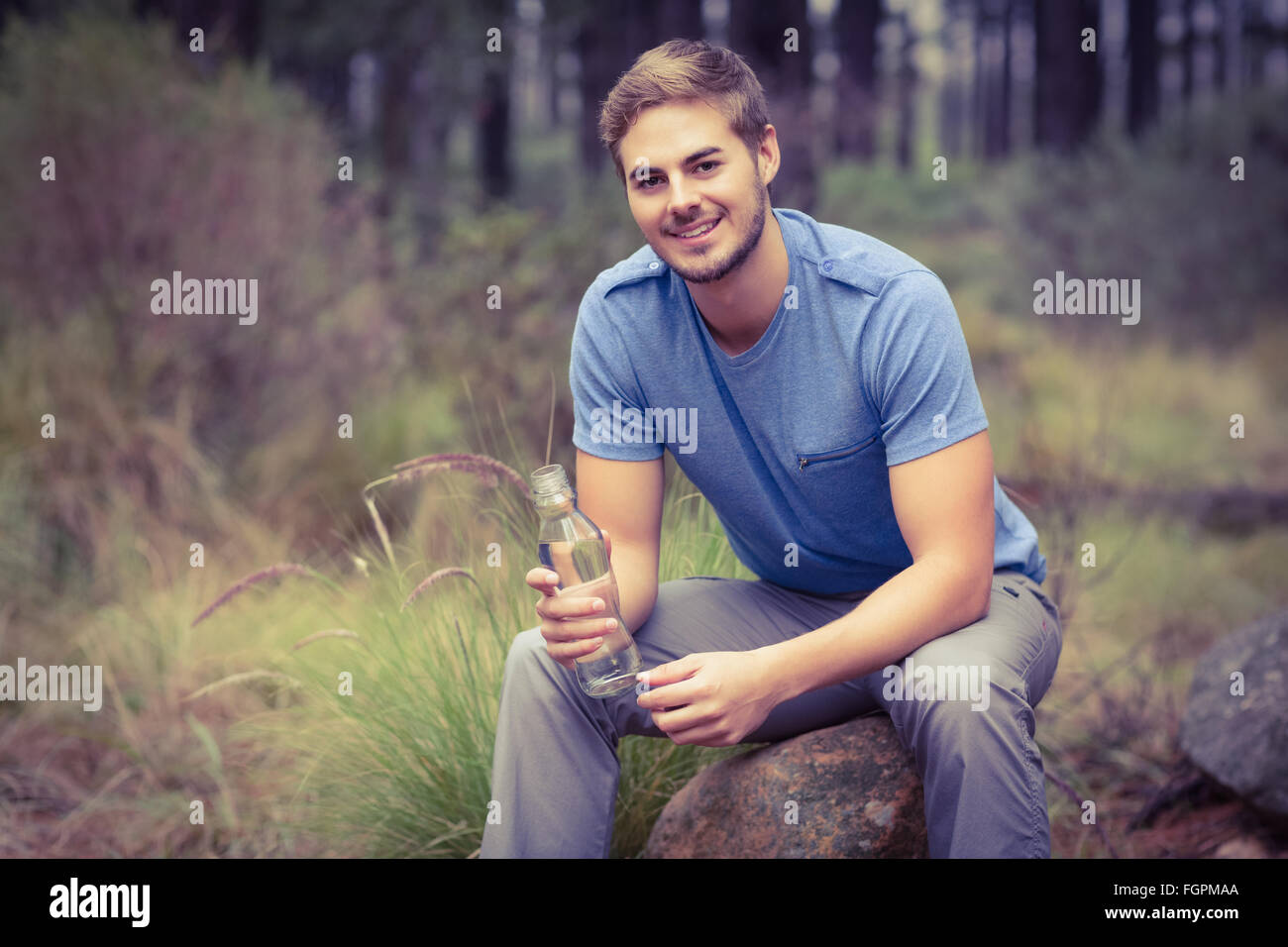 Portrait of a handsome man sitting on a stone Stock Photo - Alamy