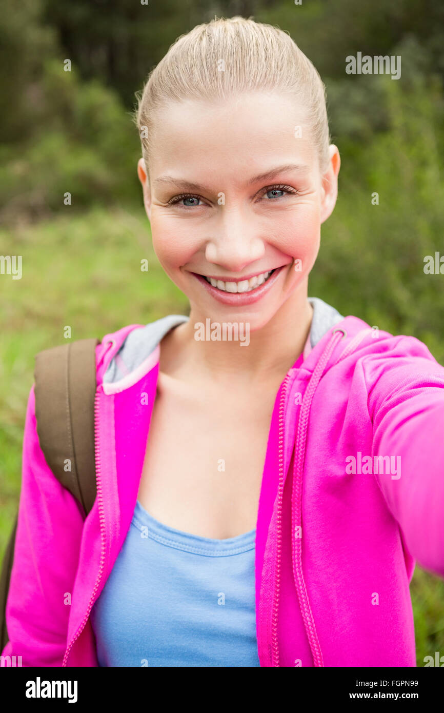 Smiling female hiker taking a selfie Stock Photo - Alamy