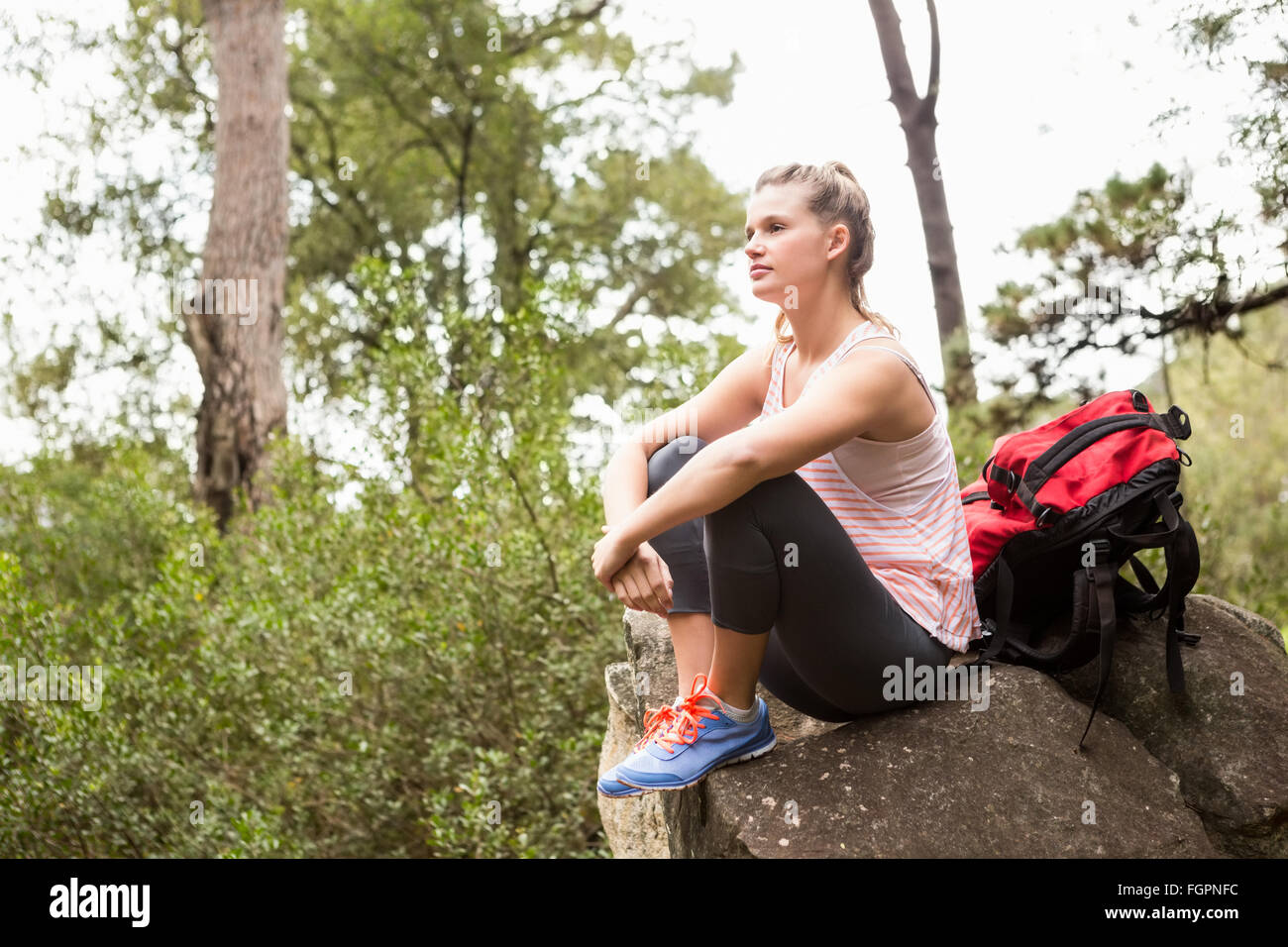 Blonde hiker sitting on rock and viewing the landscape Stock Photo - Alamy