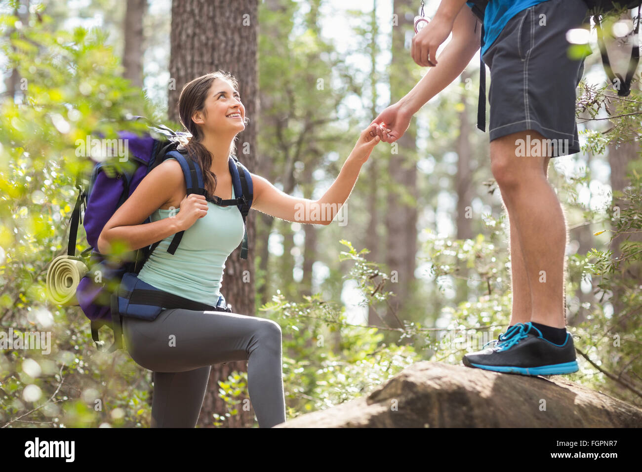 Happy hikers climbing on rock Stock Photo - Alamy
