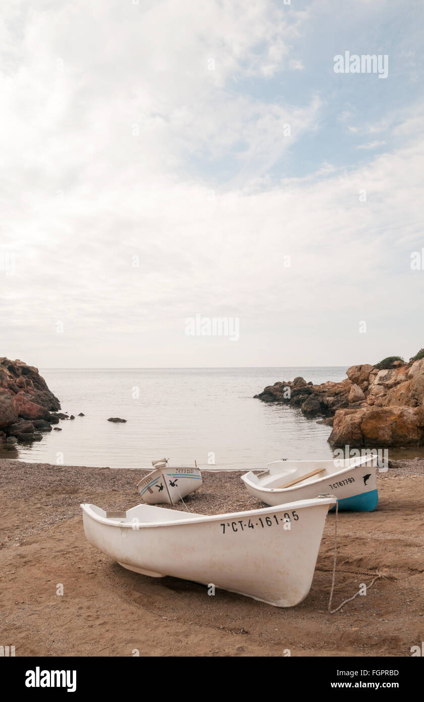 Small fishing boats resting on the sandy beach at Isla Plana, near, Puerto de Mazarron, Murcia, Spain Stock Photo