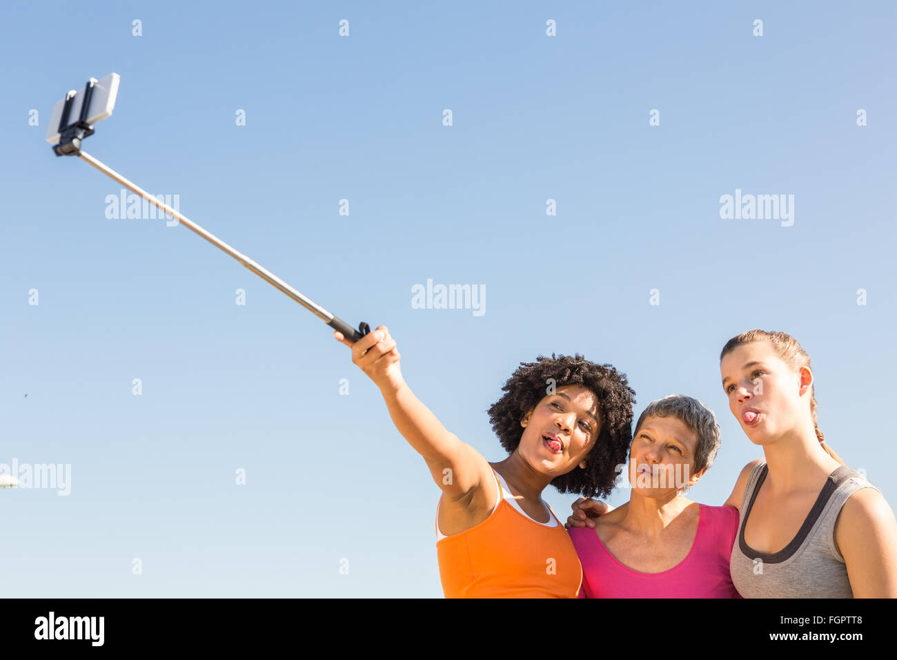 Sporty women posing and taking selfies with selfiestick Stock Photo - Alamy