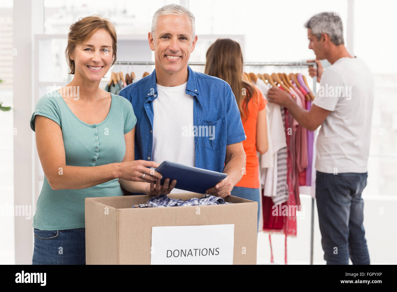 Smiling casual business colleagues with donation box Stock Photo