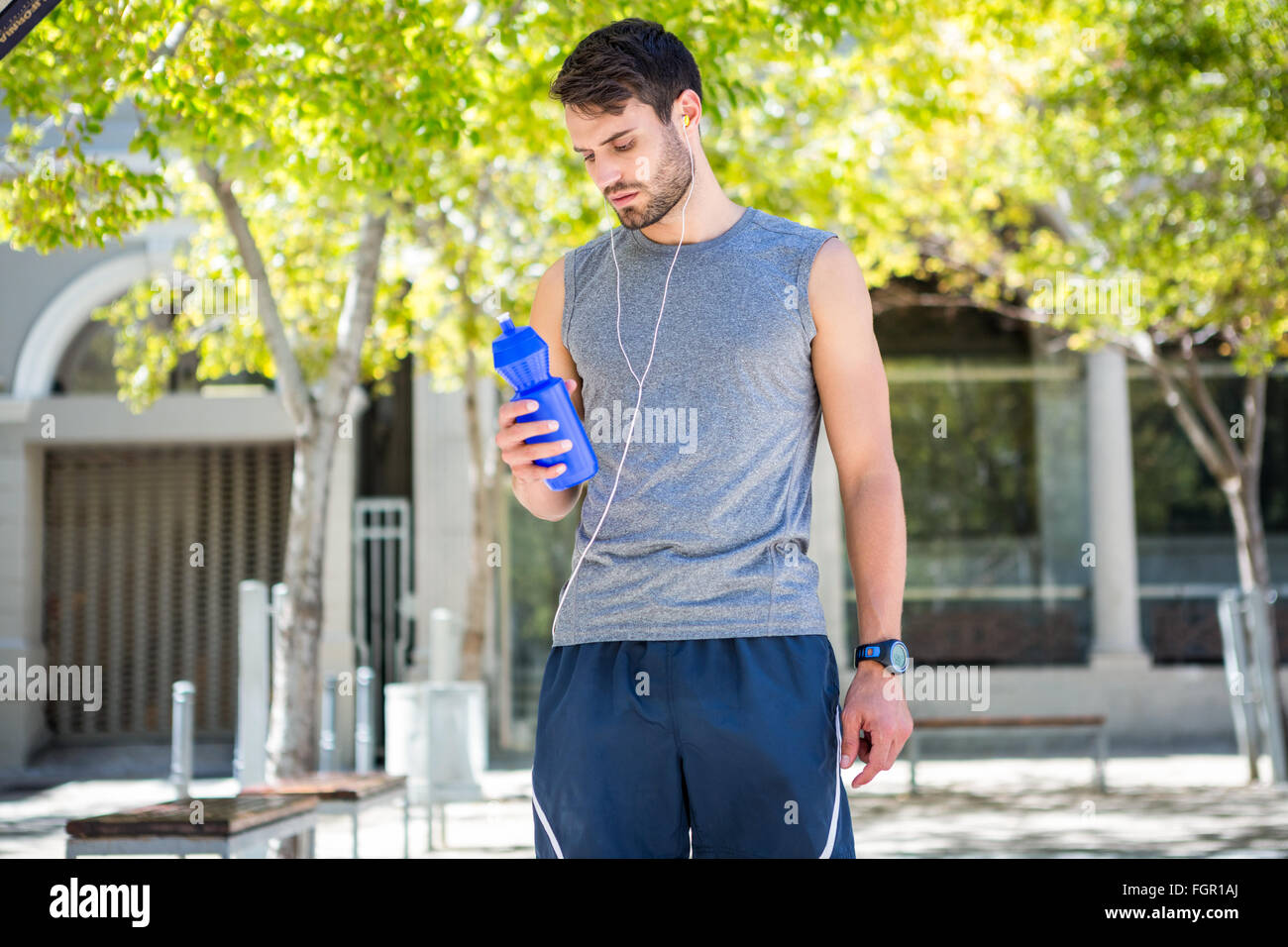 Handsome runner holding a water bottle Stock Photo - Alamy