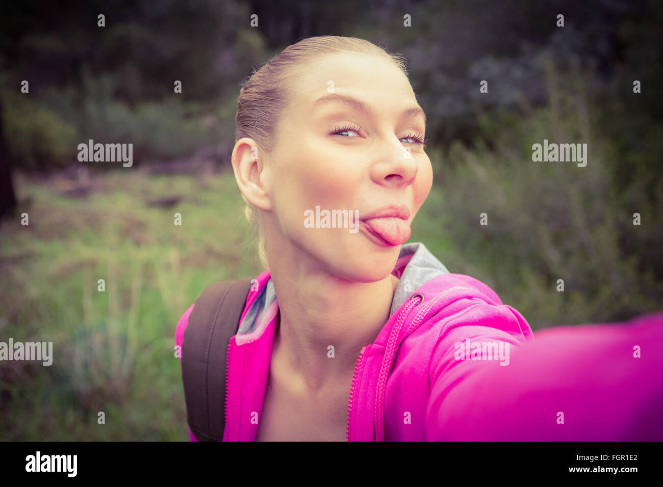 Smiling female hiker taking a funny selfie Stock Photo - Alamy