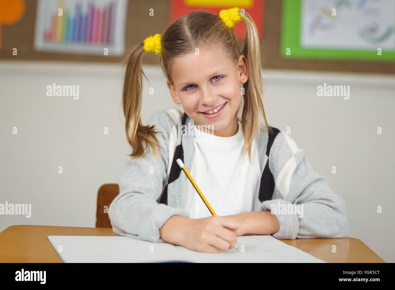 Cute pupil working at her desk in a classroom Stock Photo - Alamy