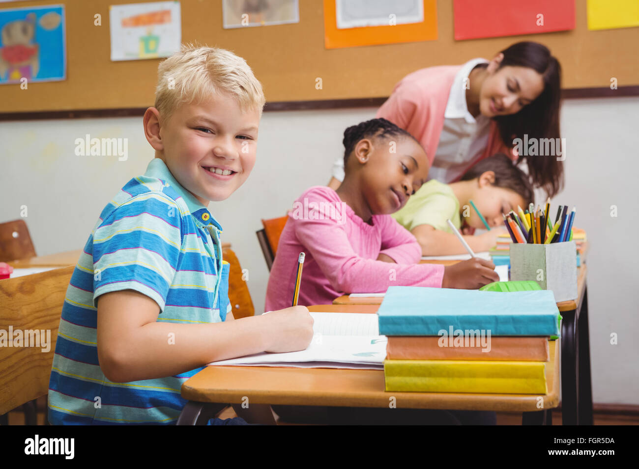 Smiling teacher helping a student Stock Photo - Alamy