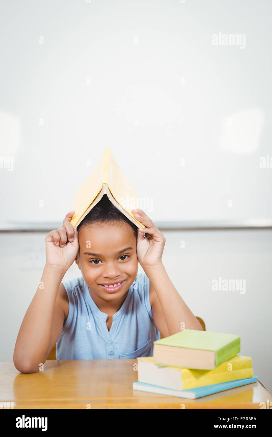 Student holding a book over her head Stock Photo - Alamy