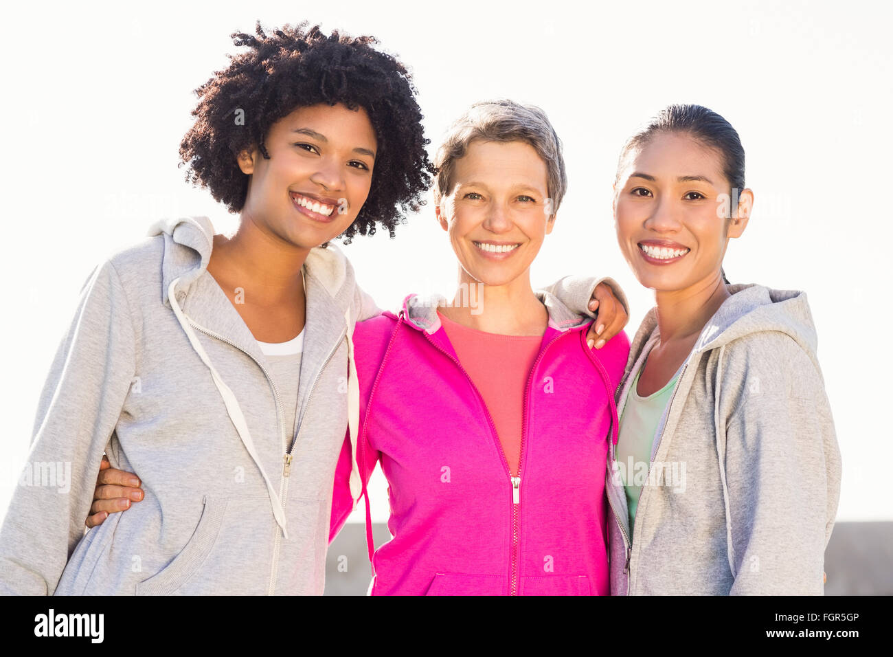 Smiling sporty women with arms around each other Stock Photo - Alamy