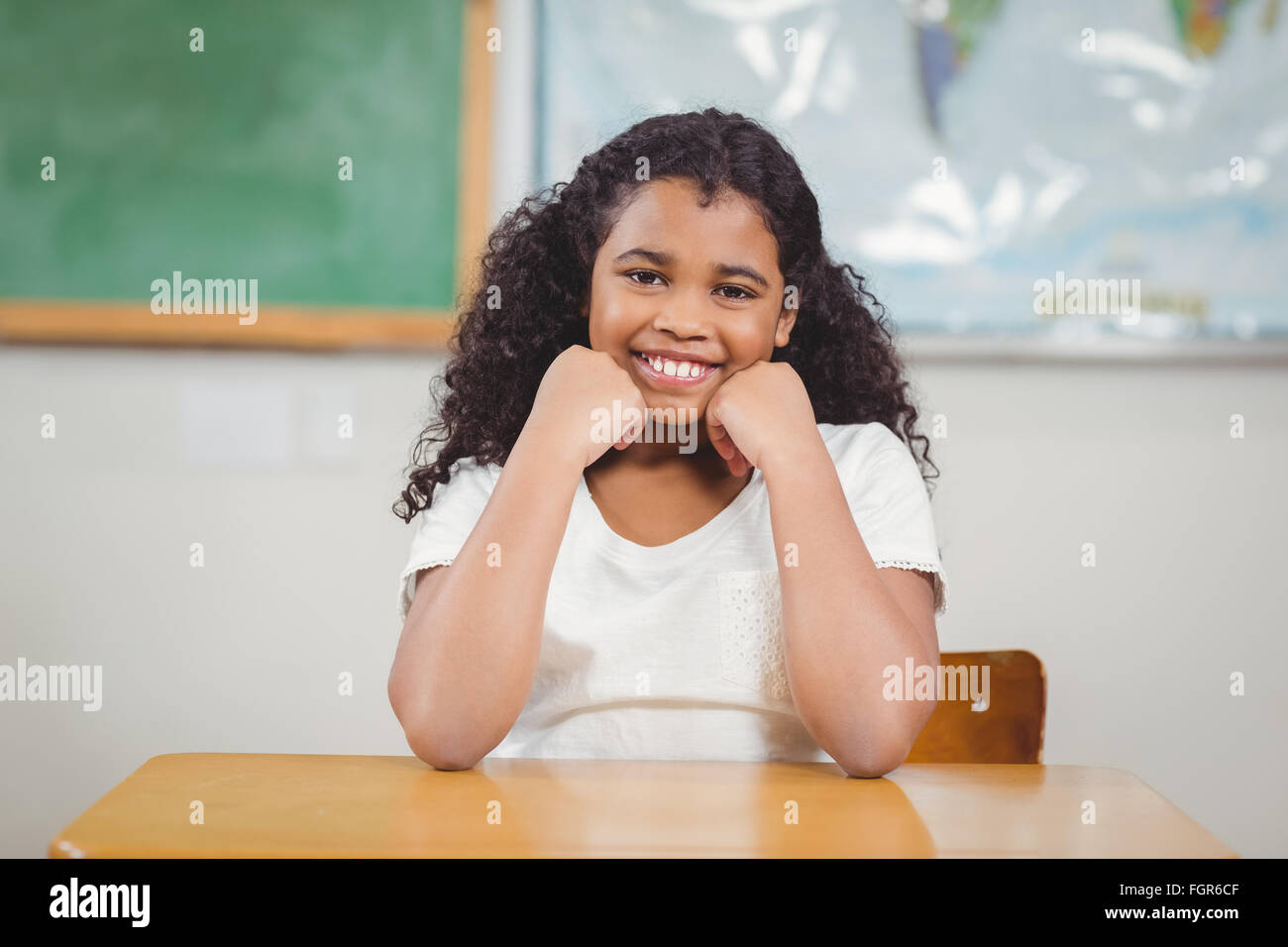 Smiling pupil sitting in a classroom Stock Photo - Alamy