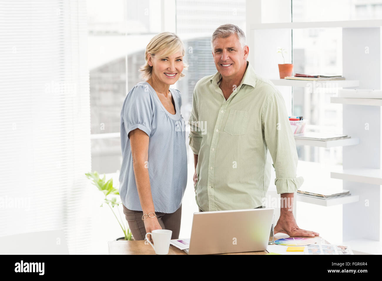 Smiling business team looking at the camera Stock Photo - Alamy