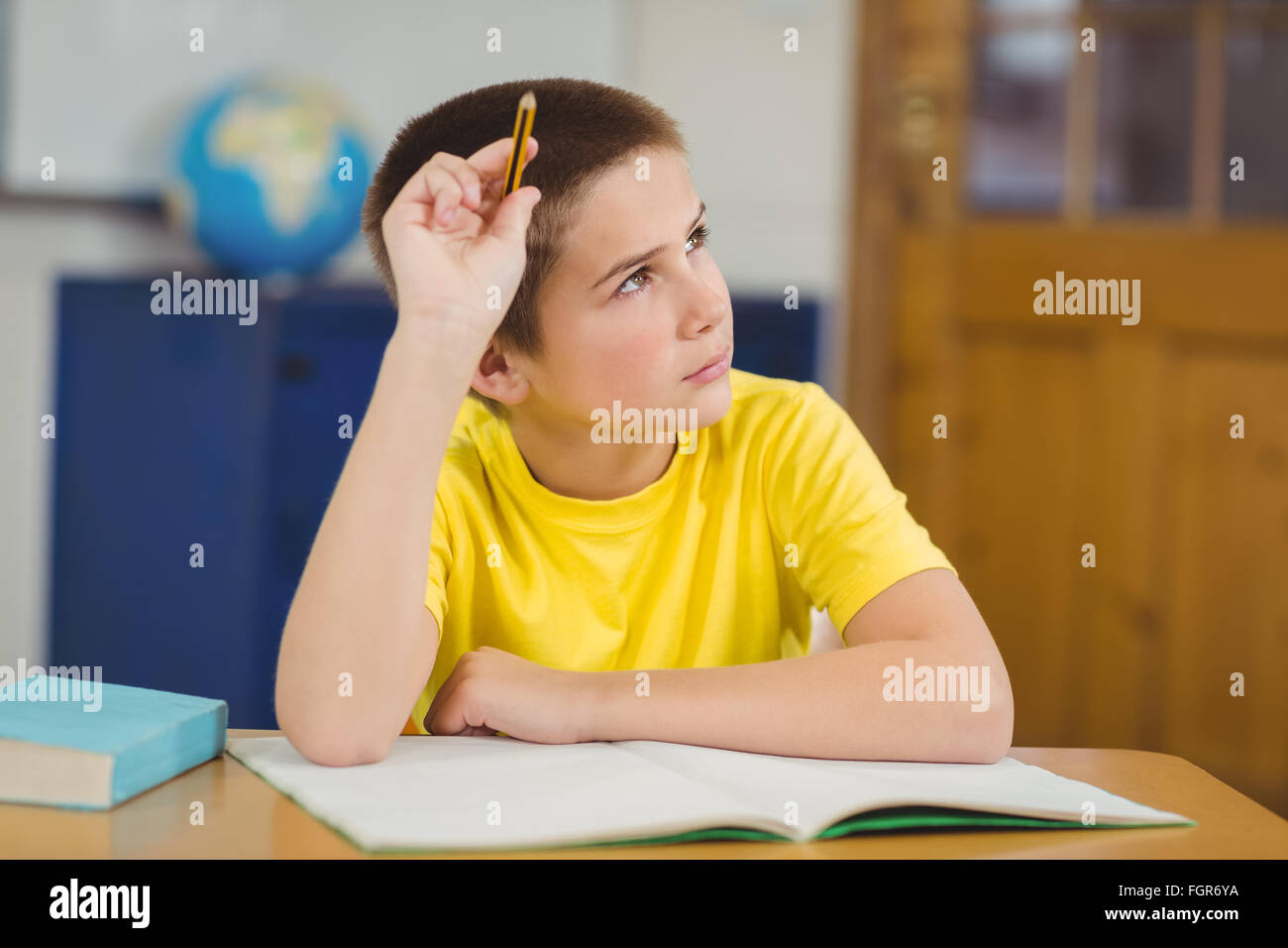 Concentrated pupil working at his desk in a classroom Stock Photo - Alamy