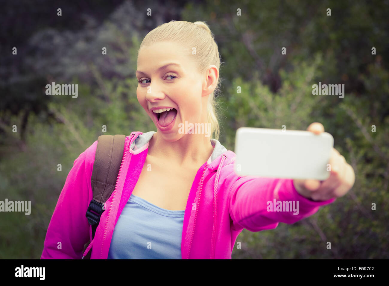 Smiling female hiker taking a funny selfie Stock Photo - Alamy