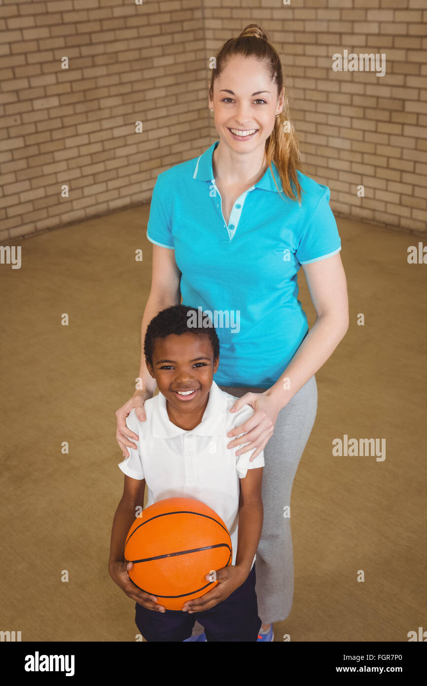 Student holding basketball with teacher Stock Photo