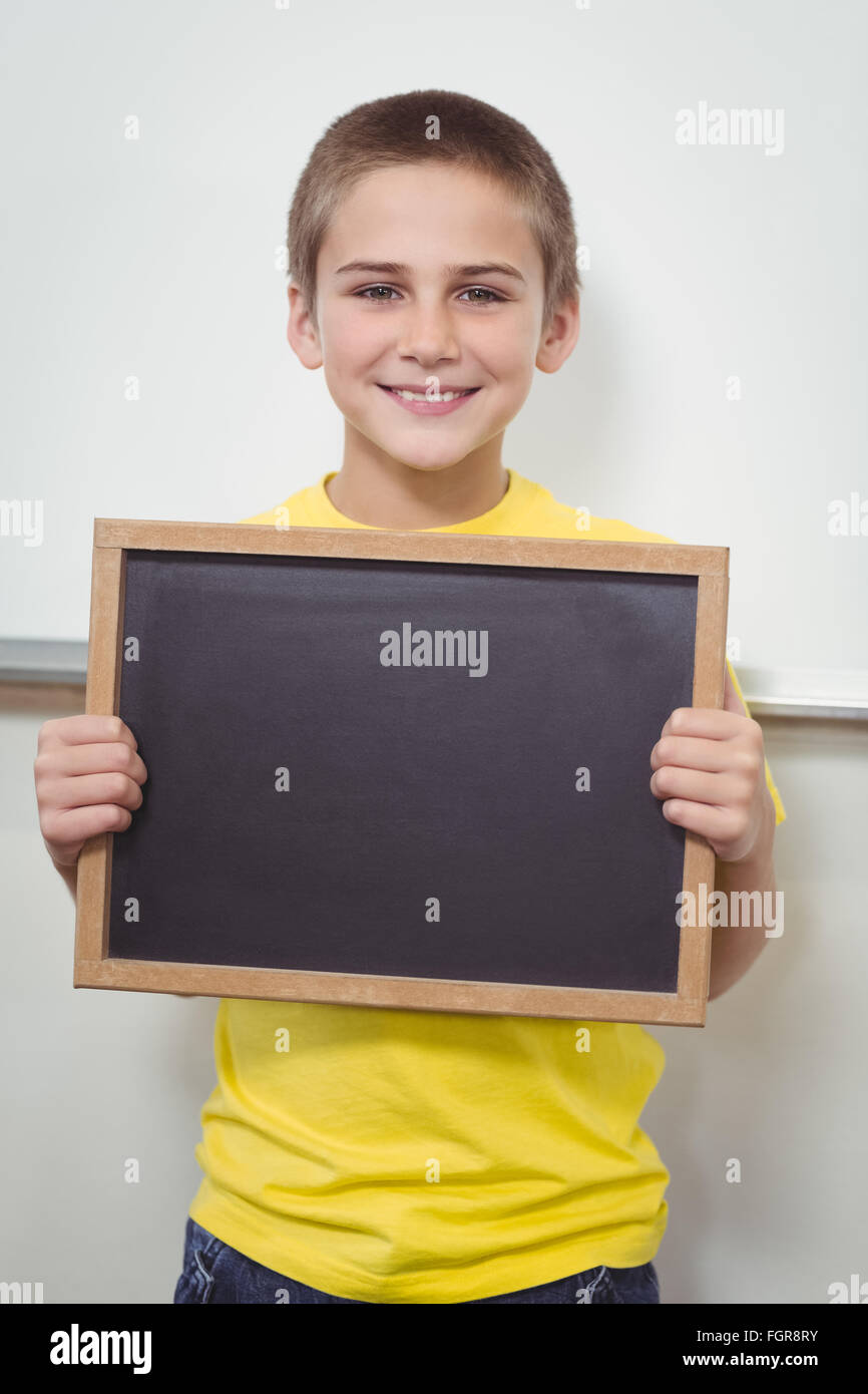 Smiling pupil holding chalkboard in a classroom Stock Photo - Alamy