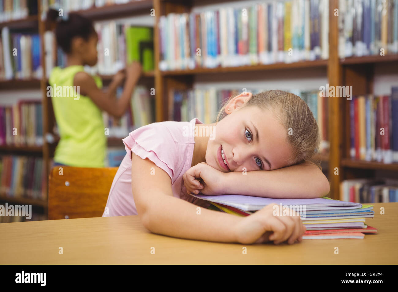 Student resting her head on some books Stock Photo - Alamy
