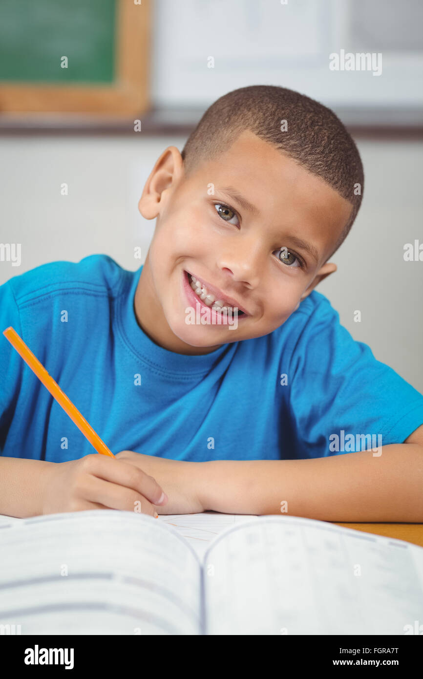 Cute pupil working at his desk in a classroom Stock Photo - Alamy