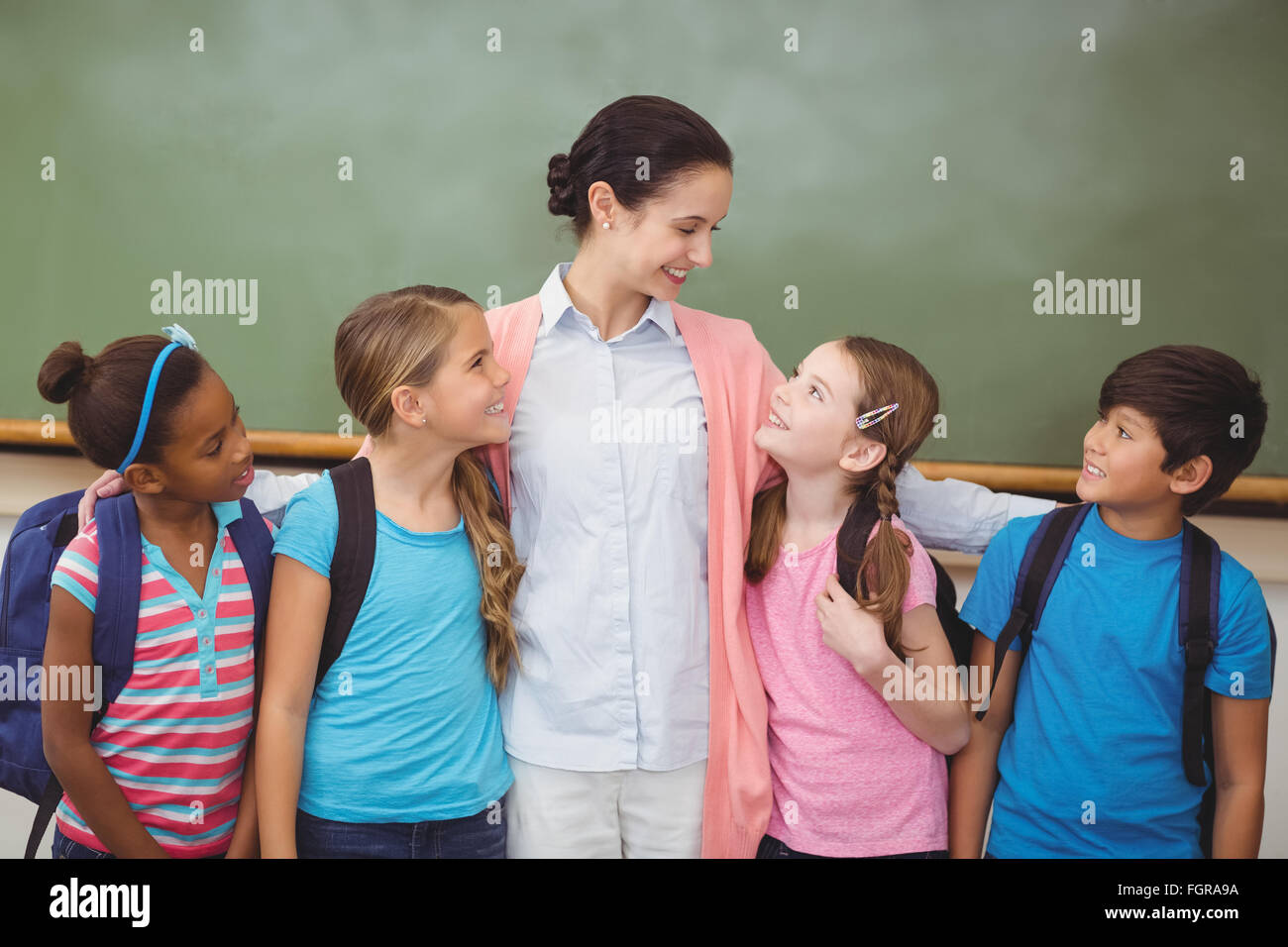Teacher and pupils smiling in classroom Stock Photo - Alamy