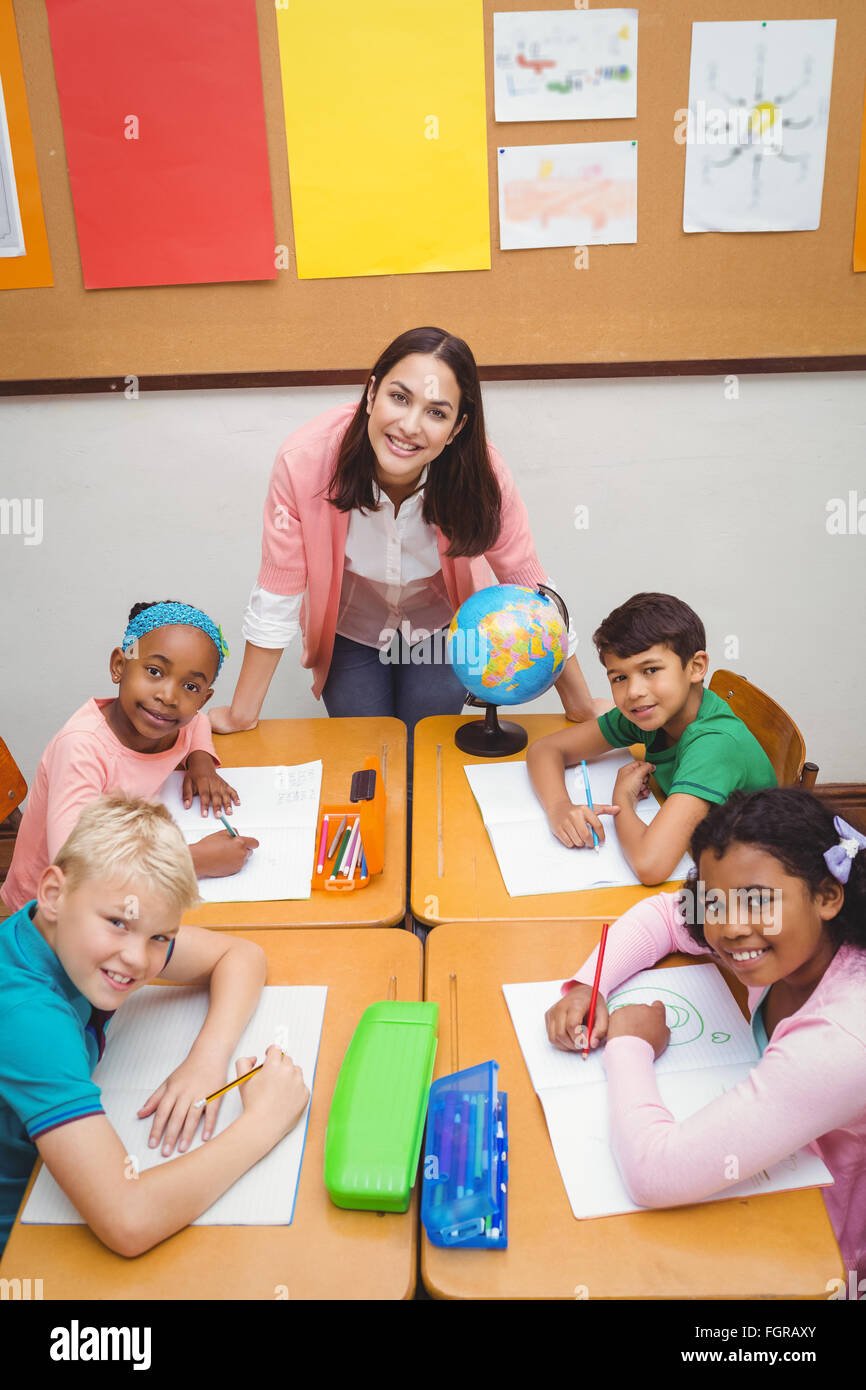 Smiling students and teacher looking at the camera Stock Photo - Alamy