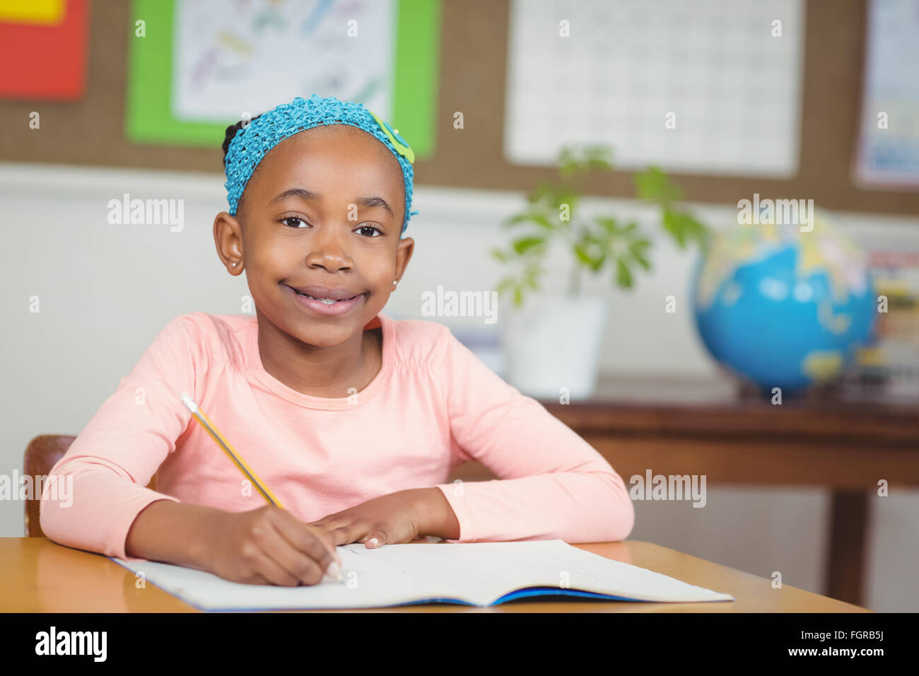 Cute pupil working at her desk in a classroom Stock Photo - Alamy