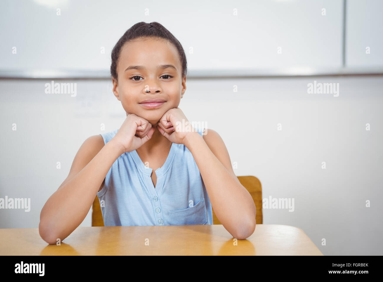 Smiling student resting head in her hands Stock Photo - Alamy