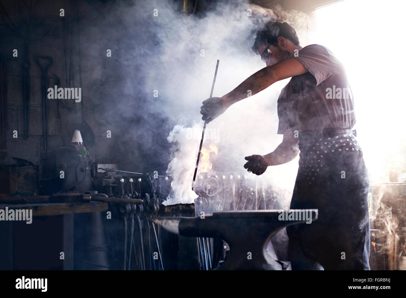 Blacksmith heating iron tool in Stock Photo Alamy