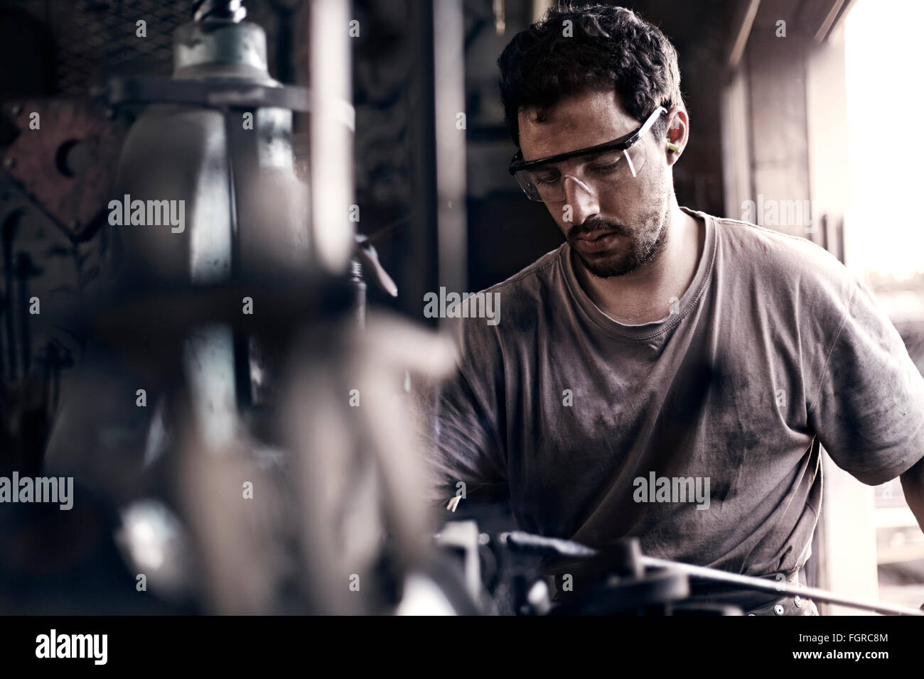 Focused blacksmith shaping iron in forge Stock Photo - Alamy